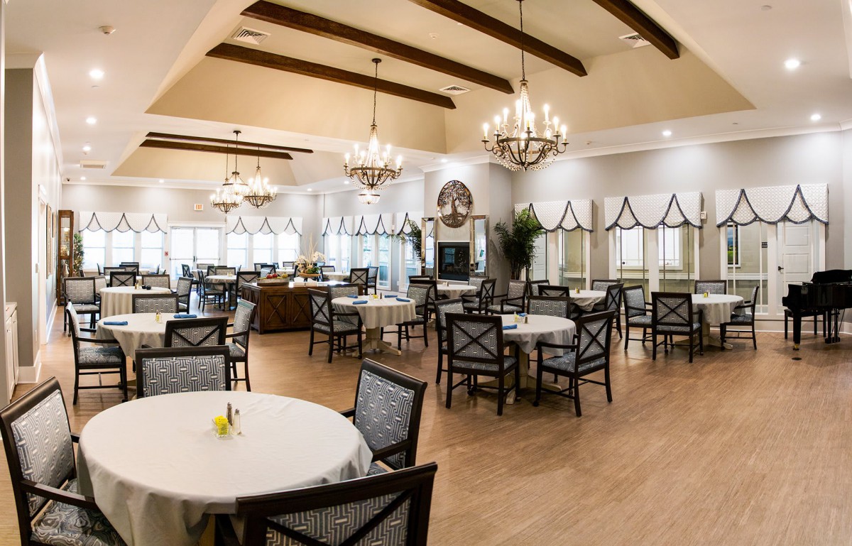 An elegant and spacious dining room with chandeliers and neatly arranged tables and chairs.