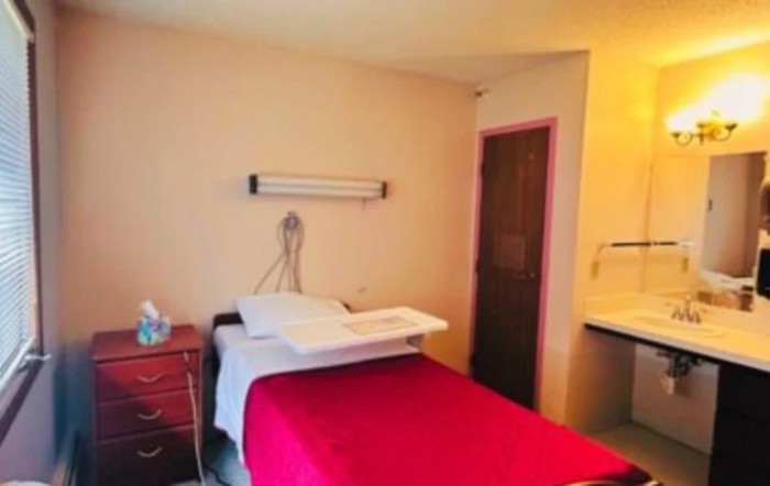 A simple hospital room with a bed and minimal furnishings.