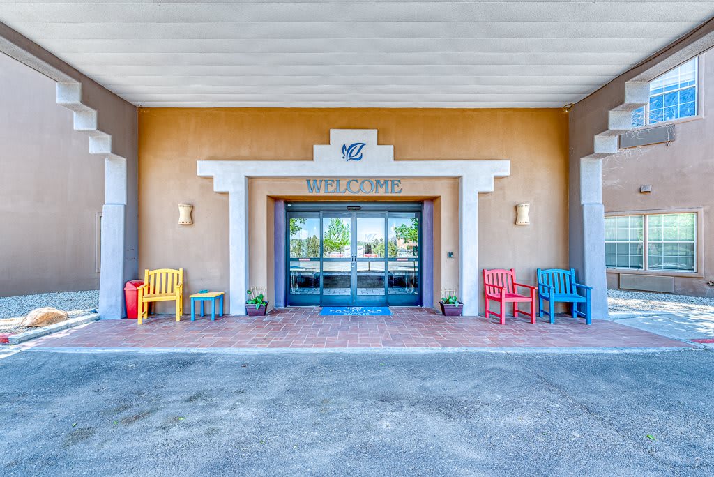Entrance of a building with colorful chairs and architectural elements.