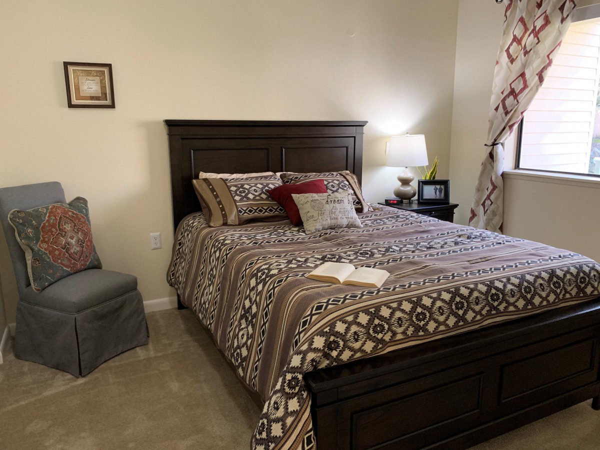 A cozy bedroom with a neatly made bed and warm lighting.