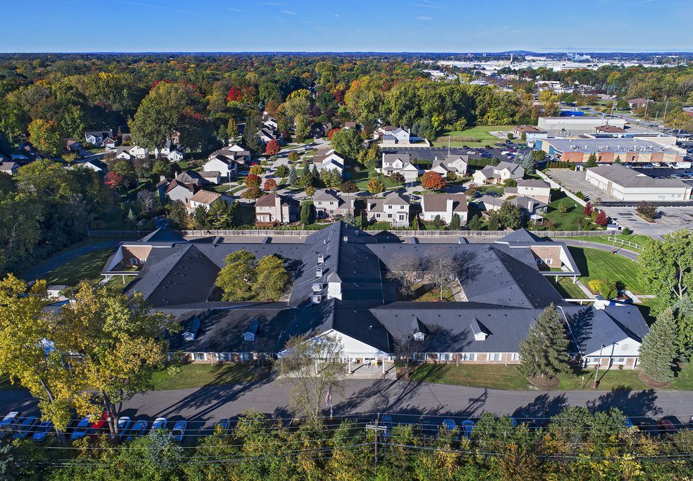 Aerial view of a residential neighborhood with various buildings surrounded by trees.