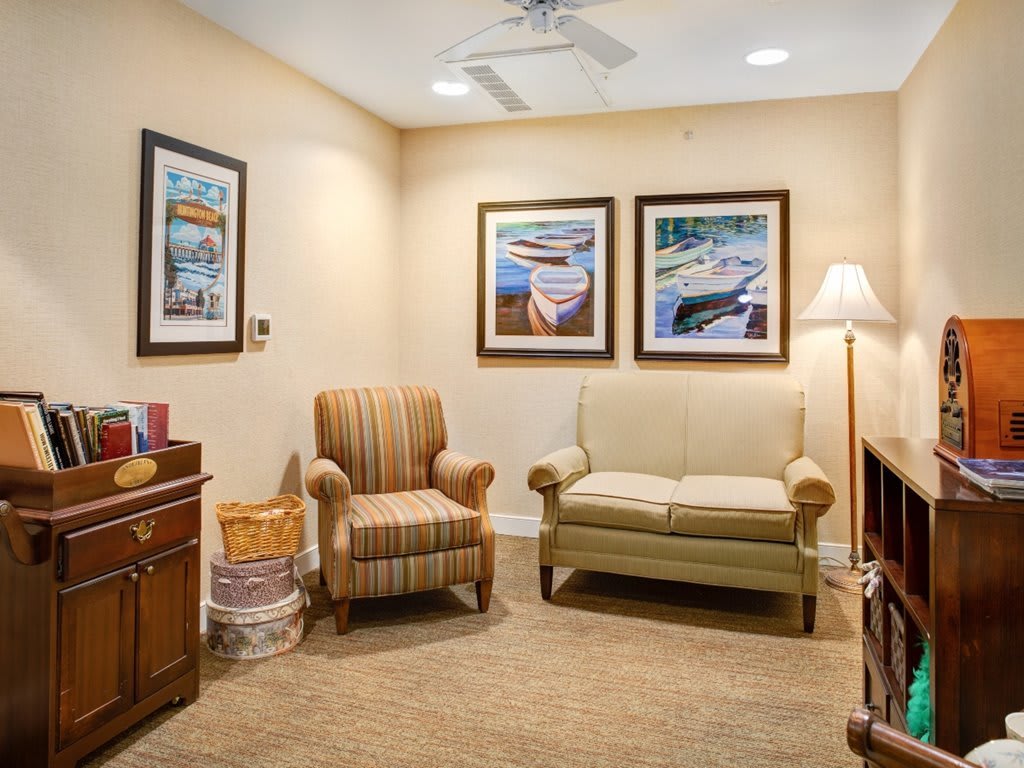A cozy waiting room with comfortable seating and framed artwork on the walls.