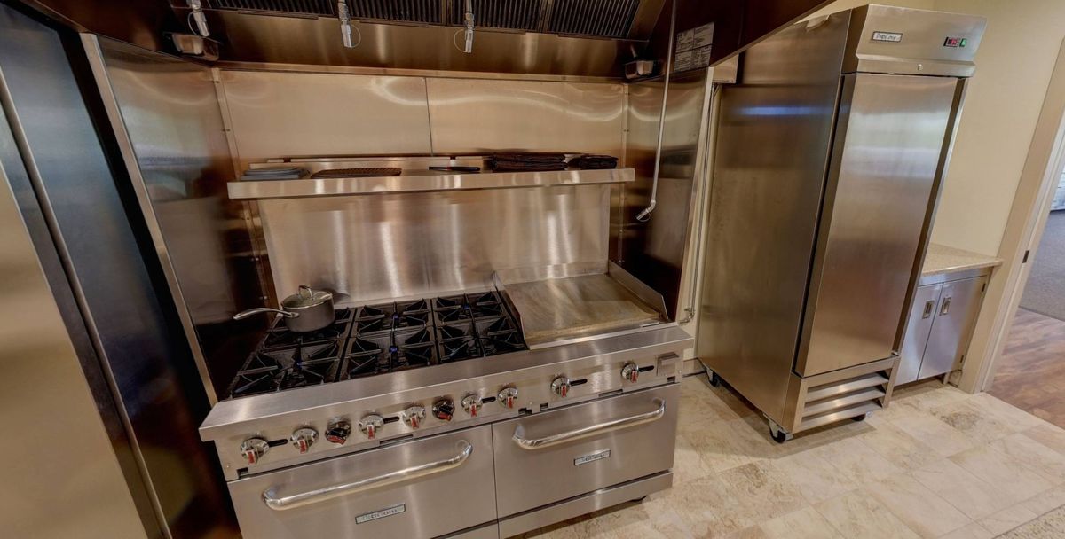 A commercial kitchen setup with a stainless steel stove and oven.