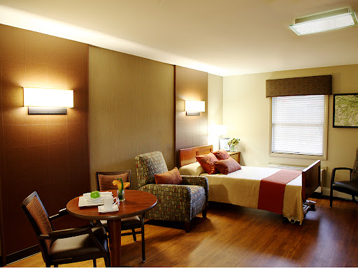 A cozy living space featuring a bed, seating area, and dining table with warm lighting.