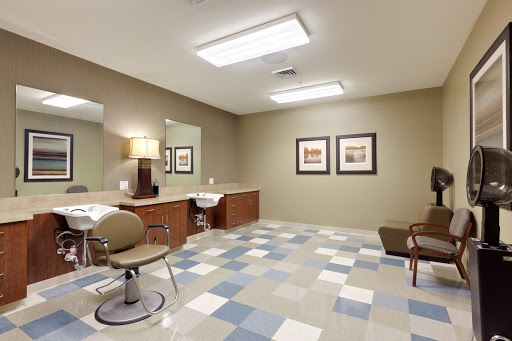 A spacious and well-lit hair salon area featuring modern furniture and a stylish design.