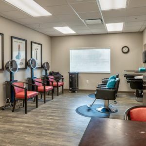 A modern salon with a waiting area and hair styling stations.