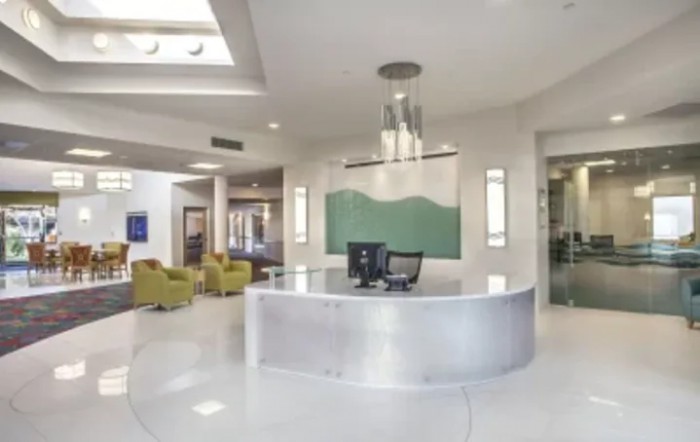 A modern office reception area with a sleek desk and contemporary lighting.
