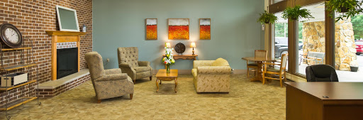 A cozy living room featuring comfortable seating and warm artwork.
