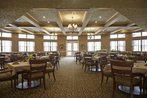 A spacious and elegantly designed dining room with well-arranged tables and classic furnishings.