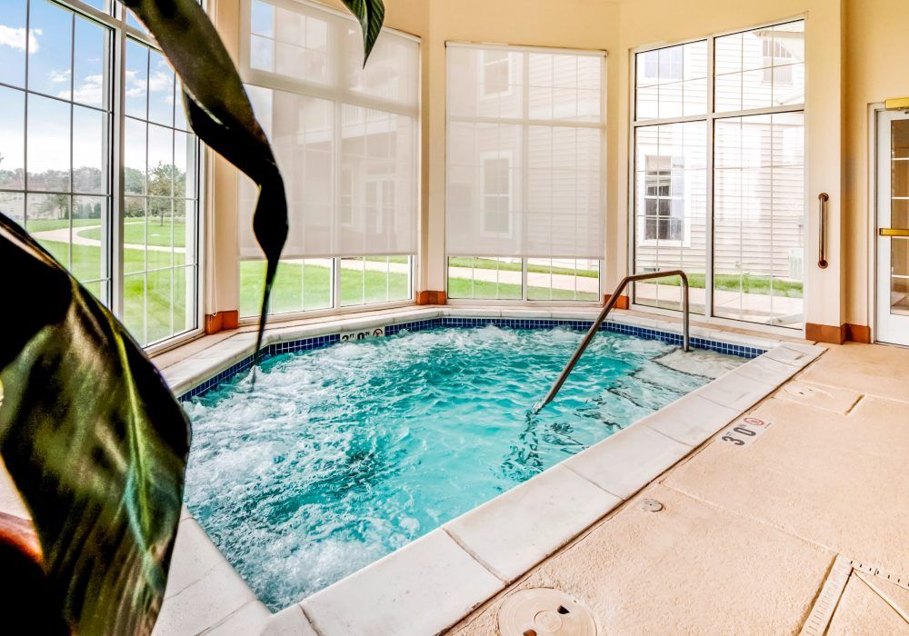 An inviting indoor jacuzzi surrounded by large windows, ideal for relaxation.