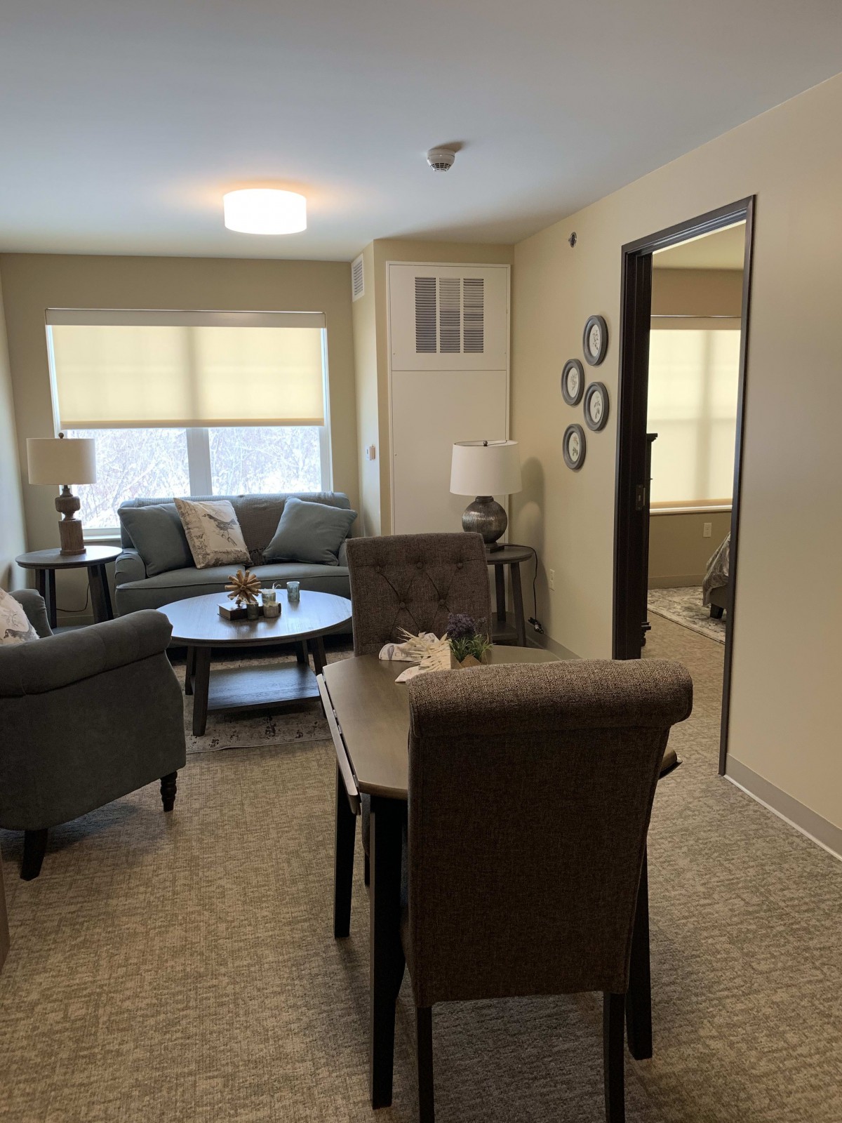 A cozy living room setup with sofas, a round table, chairs, and elegant decor.