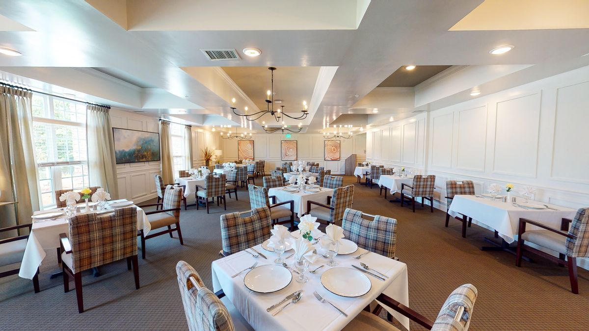 An elegantly set dining room with formal table settings and comfortable seating arrangements.
