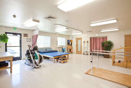 A bright and spacious physical therapy room equipped for various rehabilitation exercises.