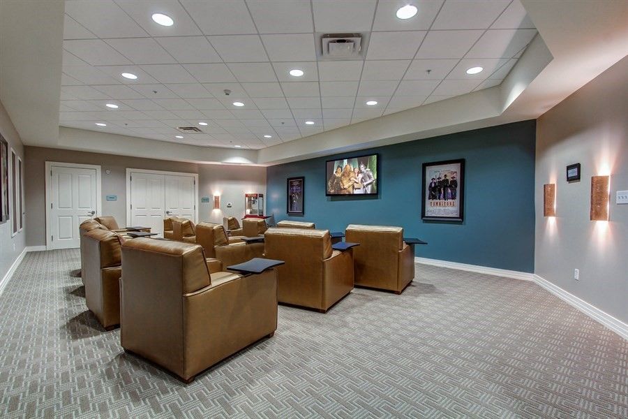 A comfortable waiting room with plush chairs and a television.