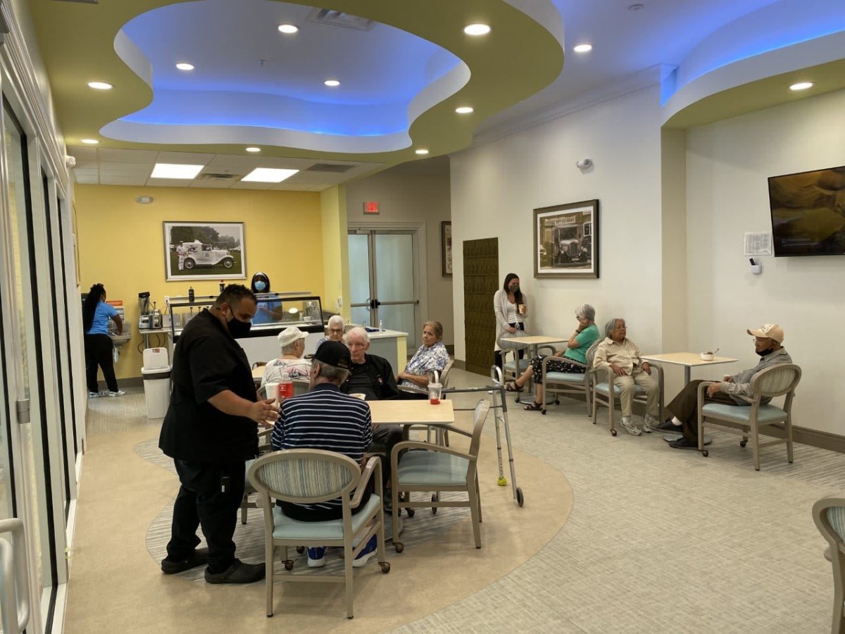 People enjoying their time at a cafe with comfortable seating and service.