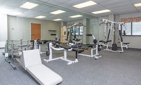 A modern gym with various exercise equipment and machines.