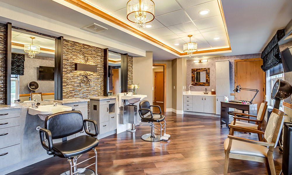 A modern hair salon with stylish interior, featuring multiple styling stations and elegant lighting.