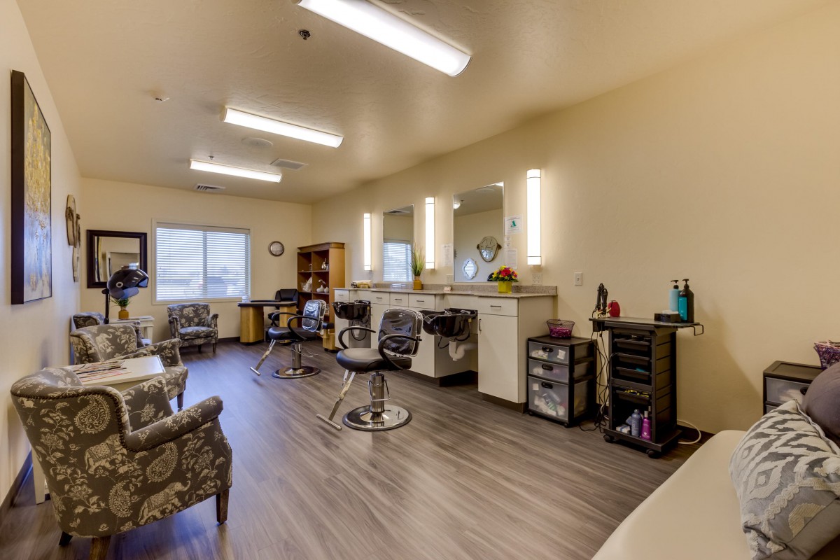 A spacious and well-lit beauty salon with multiple chairs and mirrors.