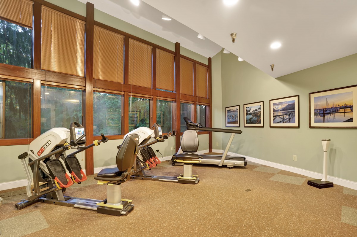 A well-lit gym with exercise equipment and a treadmill.