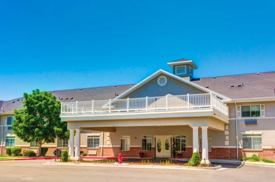A residential building with a large porch and clear blue sky.