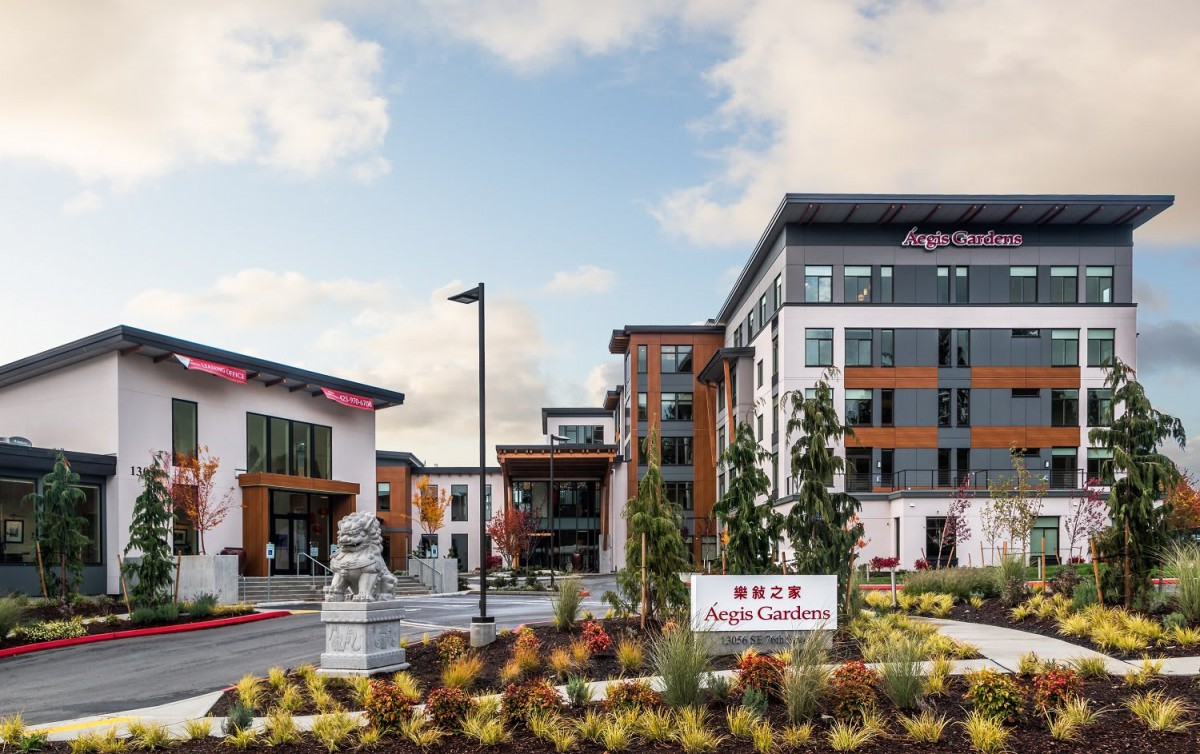 A modern Hilton Garden Inn hotel with landscaped surroundings captured during the daytime.