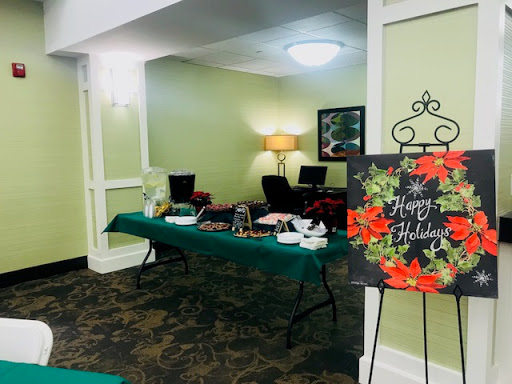 A festive holiday setup in a welcoming lobby with a decorated table and cheerful signage.