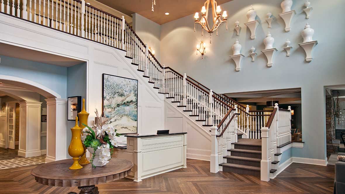 Elegant lobby with a grand staircase and chandelier.