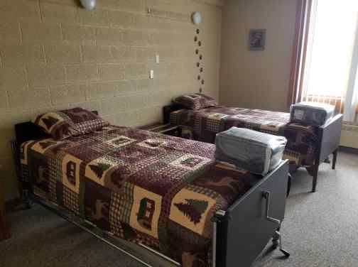 A retro-styled bedroom with twin beds and an old television set.