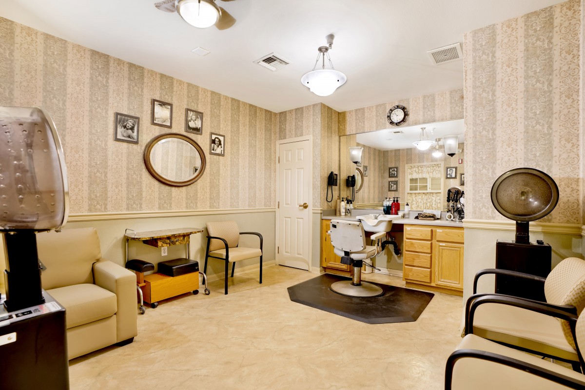 A cozy barber shop interior featuring a styling chair, mirrors, and a waiting area.