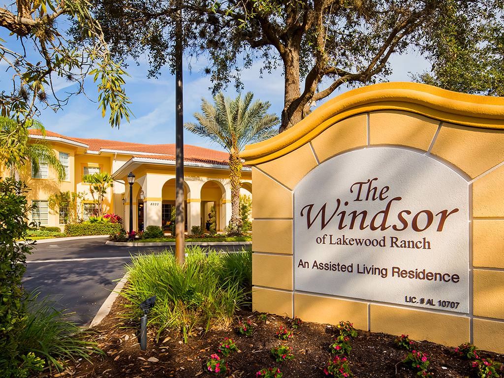 Entrance to The Windsor of Lakewood Ranch, an assisted living residence with landscaped surroundings.