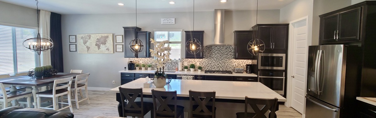 A modern kitchen with a large island, pendant lights, and a stylish backsplash.