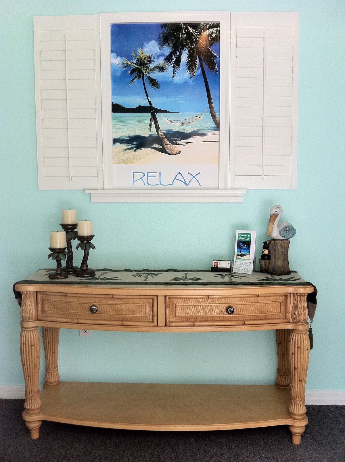 A rustic wooden table adorned with decorative items and a relaxing beach-themed artwork on the wall.