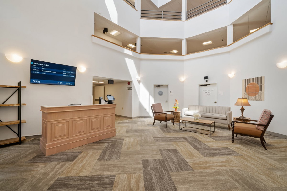 A spacious and modern hotel lobby with a reception desk and comfortable seating area.