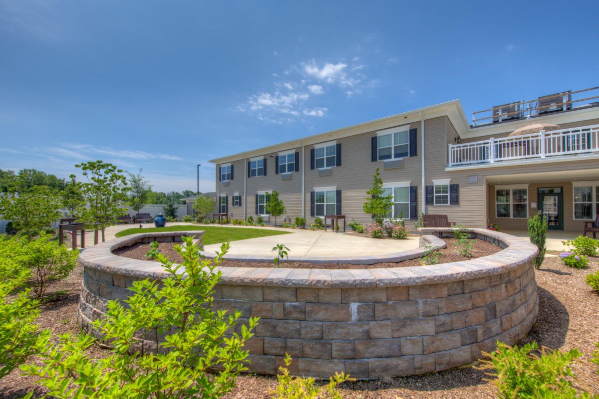A sunny view of a residential building surrounded by greenery.