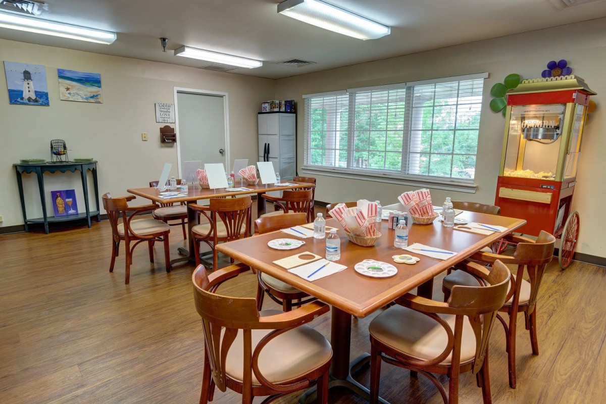 A well-lit dining area with neatly arranged tables and chairs.