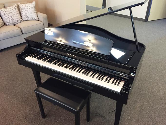 A sleek black grand piano with a matching bench.