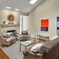 A cozy living room with a fireplace, comfortable seating, and modern artwork.