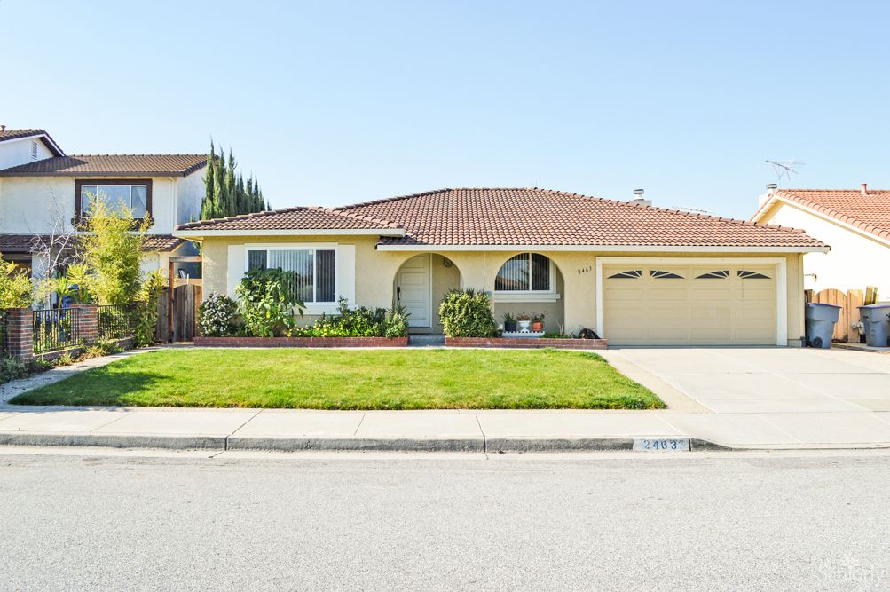 A single-story suburban house with a well-maintained front lawn and a spacious driveway.