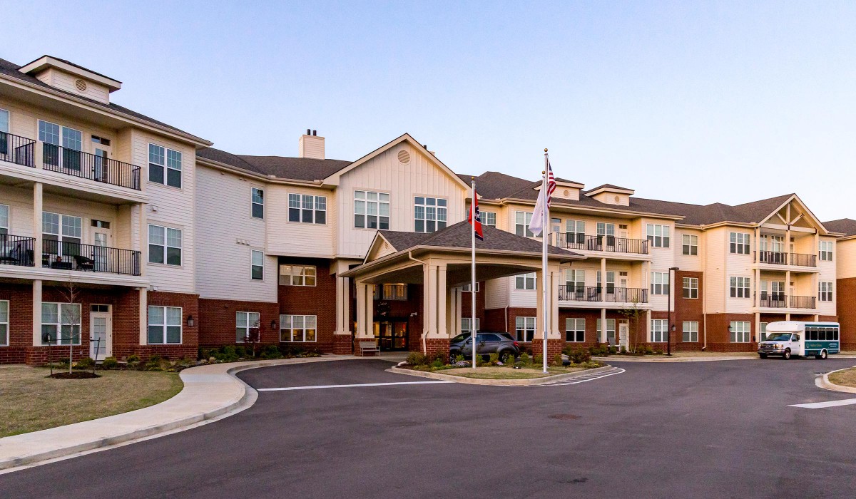 A multi-story residential building with flags at the entrance.