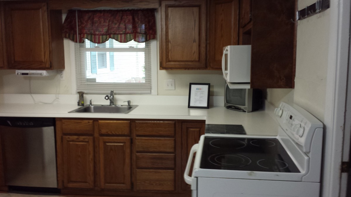 A cozy kitchen with wooden cabinets, a sink, and appliances.