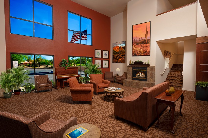 A spacious and inviting lobby with comfortable seating, a fireplace, and large windows allowing natural light.