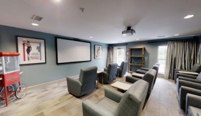 A cozy home theater setup with comfortable seating and a projector screen.