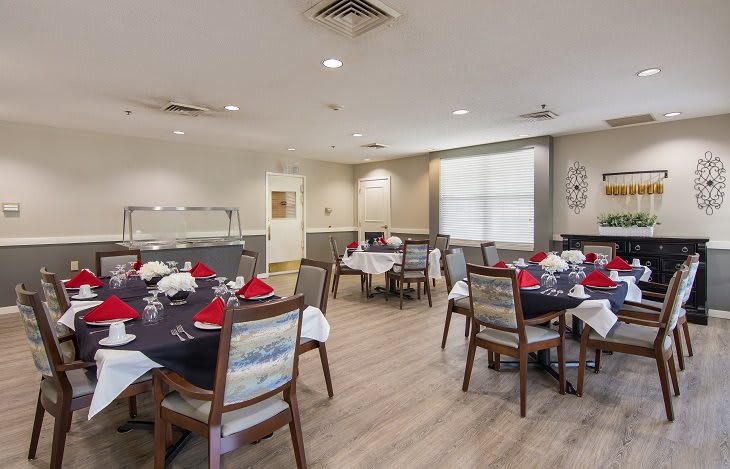 A well-arranged dining area with neatly set tables and chairs, featuring elegant table settings.