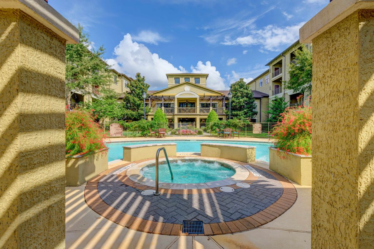 A sunny day at a residential apartment complex with a pool and hot tub.