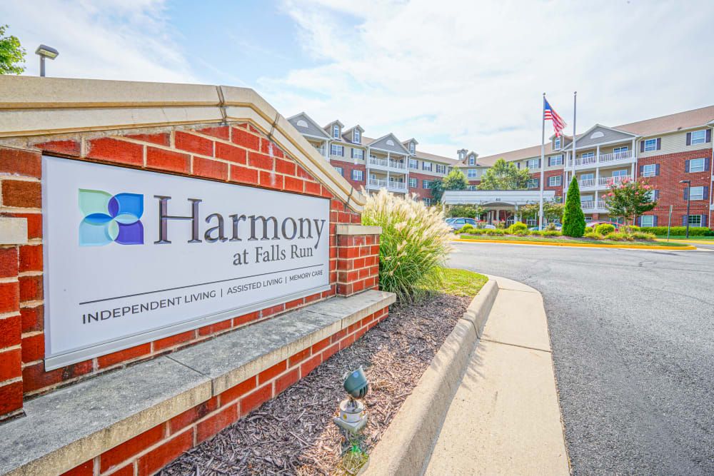 Entrance to Harmony at Falls Run Apartments with signage and landscaping.