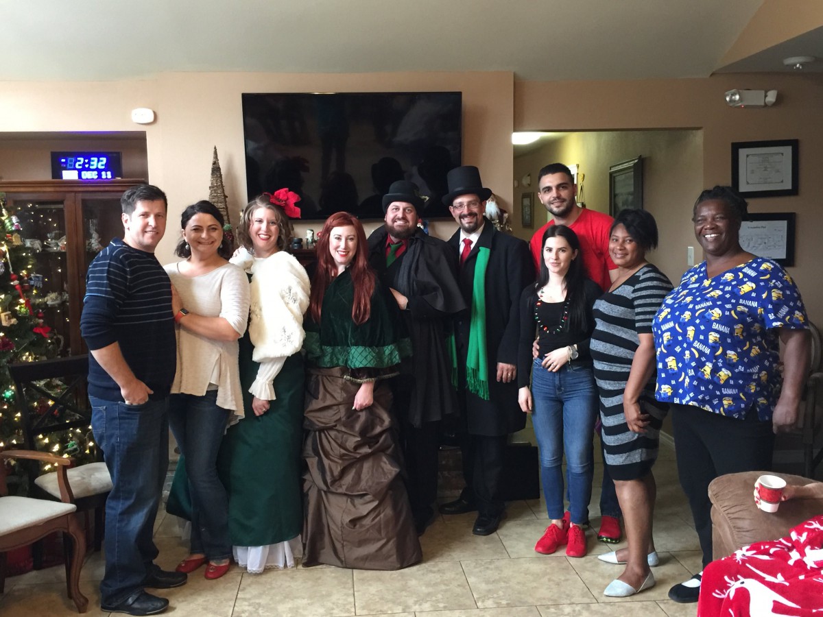 A group of people dressed in various costumes posing for a photo indoors.