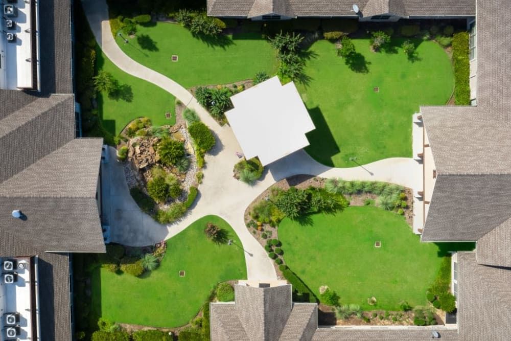Aerial view of a landscaped garden with pathways and surrounding buildings.