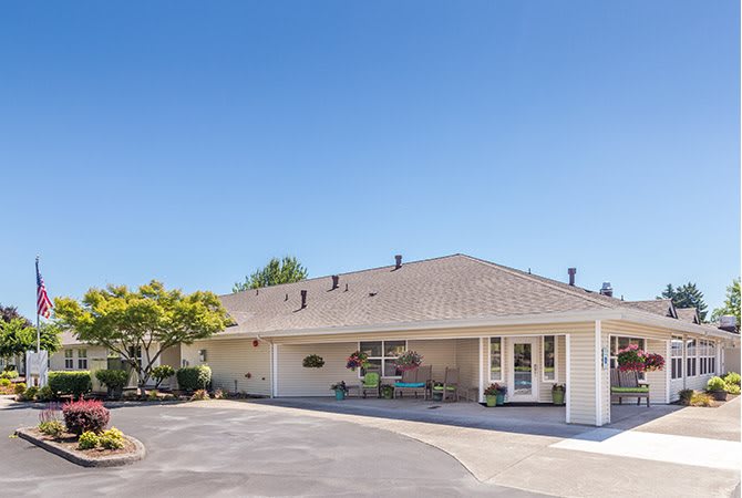 A suburban residential house with a driveway and clear blue sky.