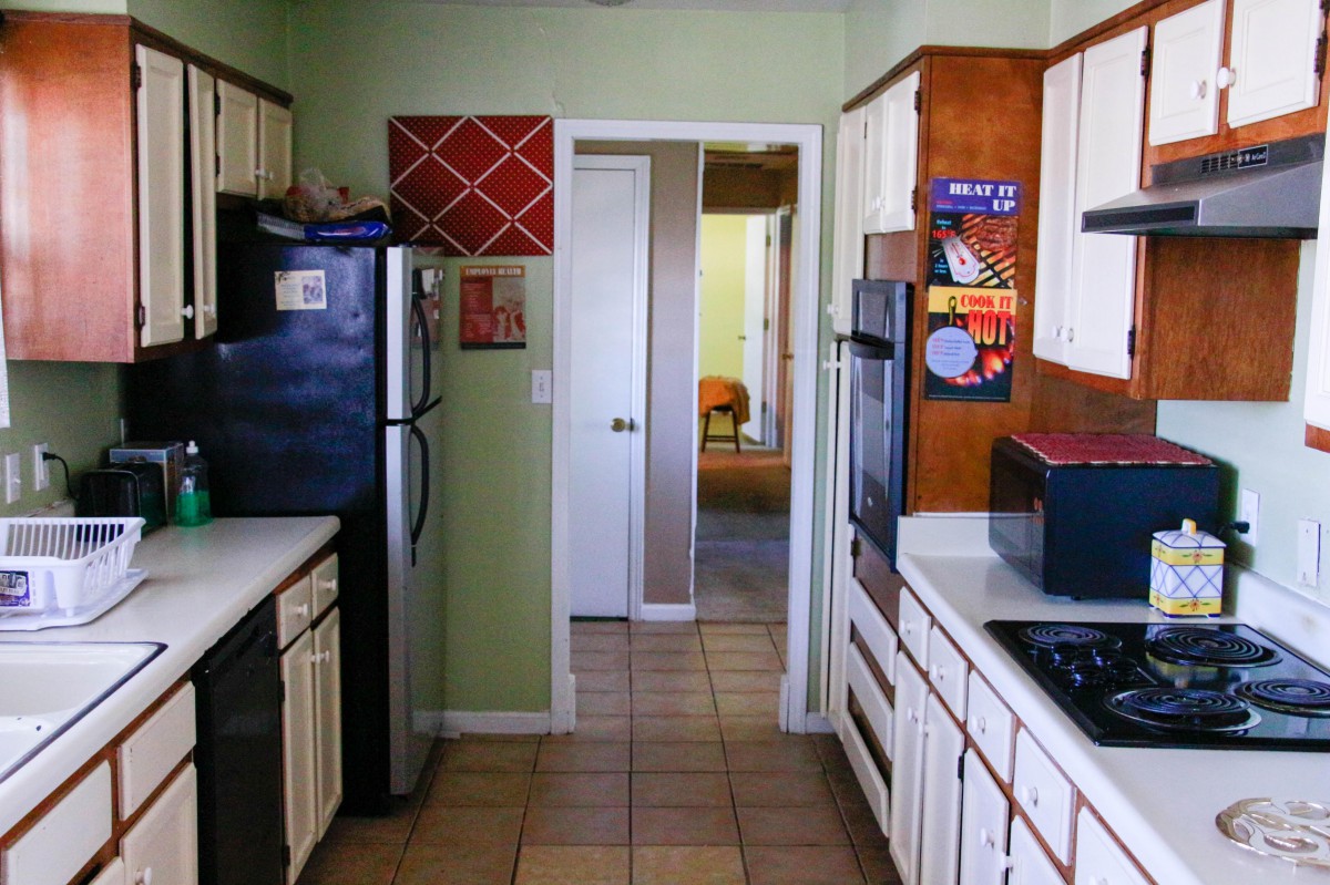 A cozy kitchen with various appliances and white cabinetry.