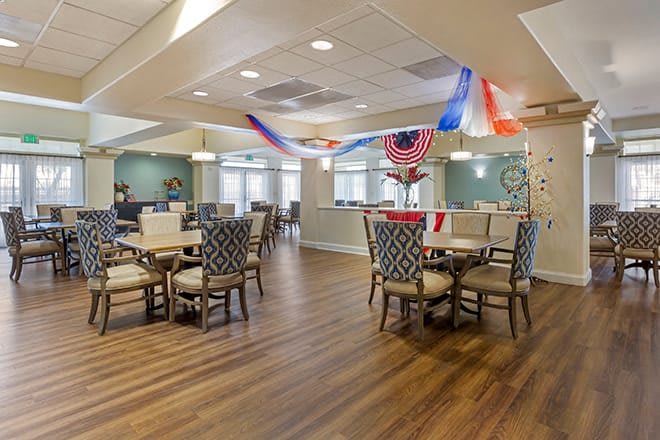 A neatly arranged dining area with patriotic decorations and wooden flooring.